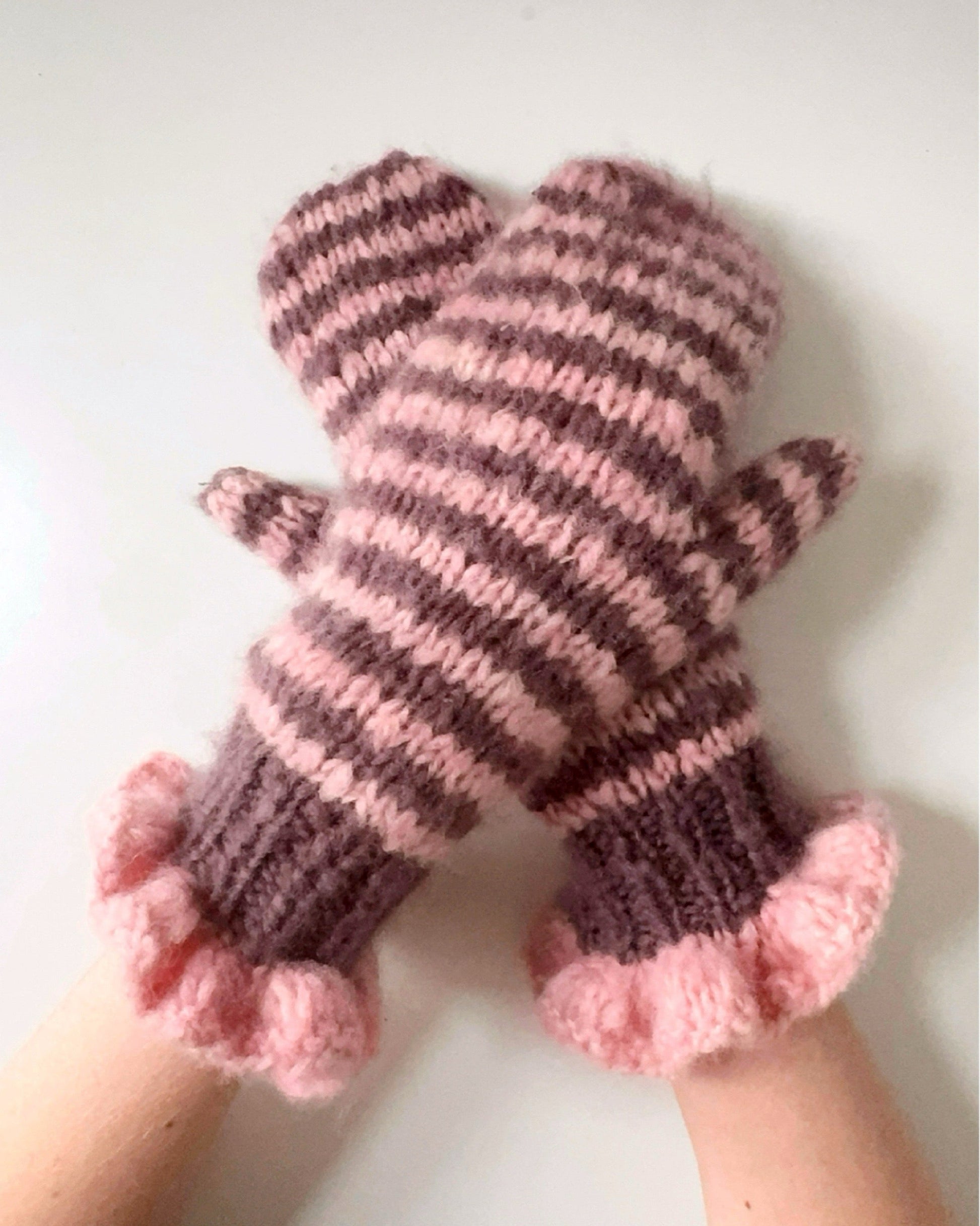Pair of pink and chocolate striped mittens with frill cuffs on a white background